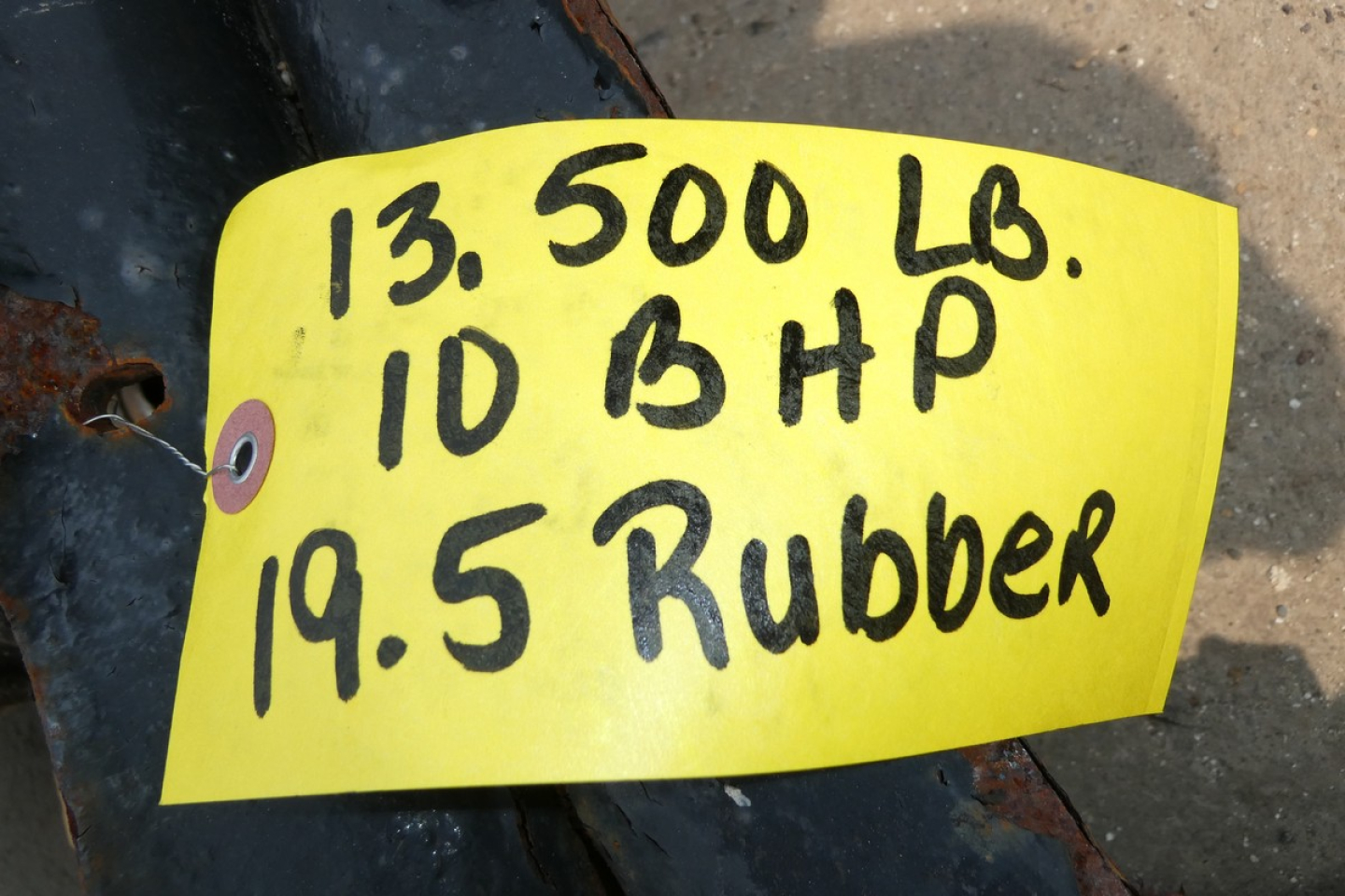 Tag on a yellow label with handwritten details: 13,500 LBS, ID BHP, 19.5 Rubber.