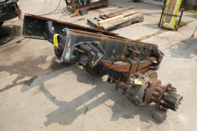 Heavy-duty truck chassis component showing axle housing and drive shaft with gears and wiring.