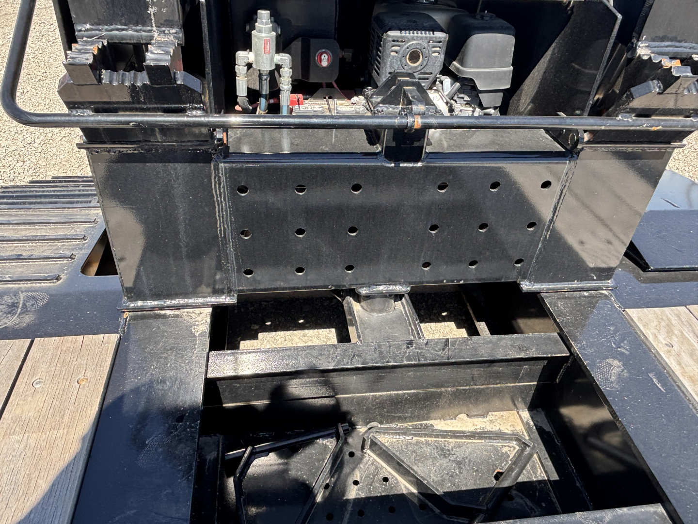 Loader king 503/554 lowboy trailer showing hydraulic pump area and battery box with perforated metal plate.