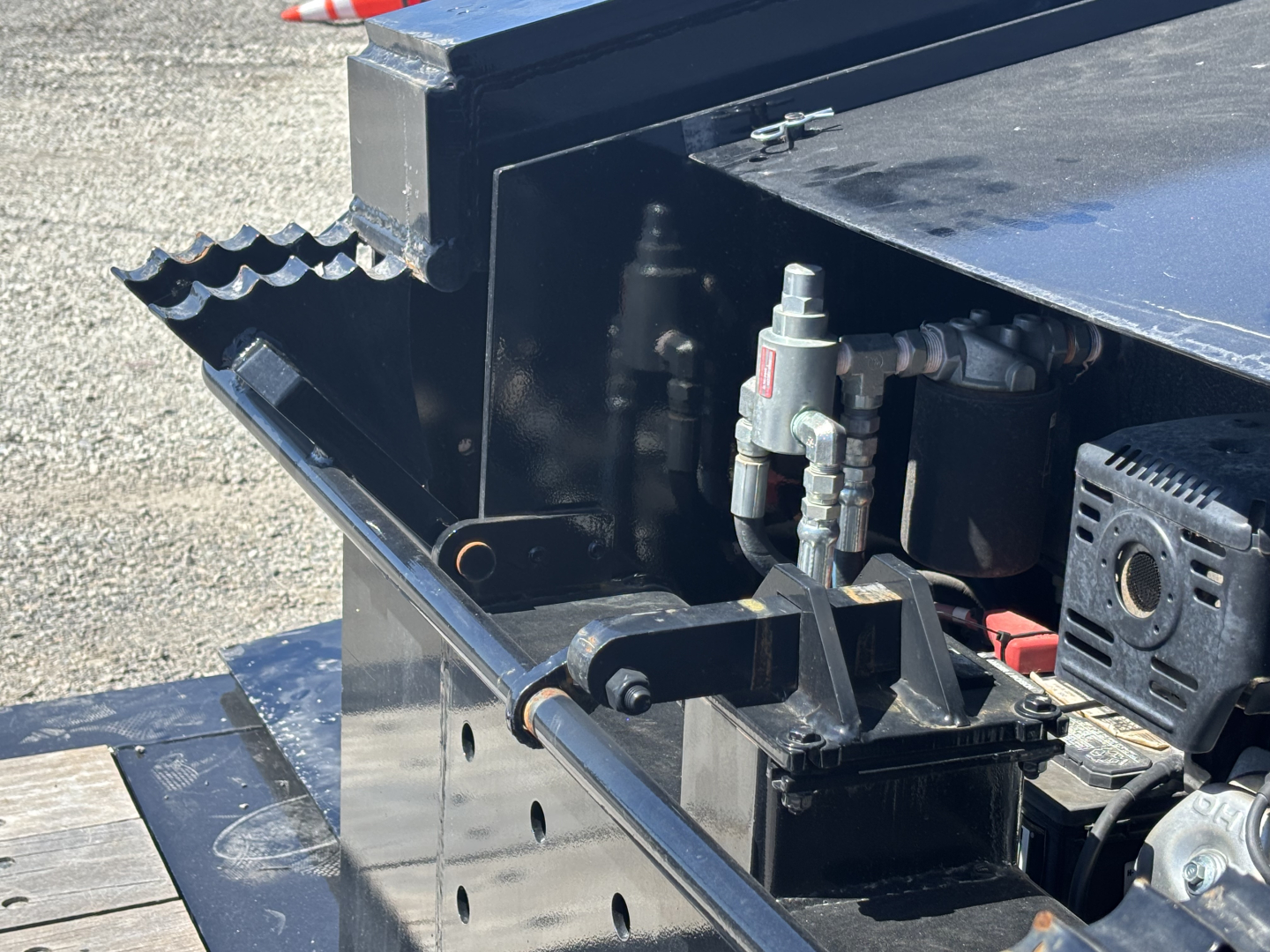 Trailer hitch area of a Load King lowboy trailer showing mechanical latching and hydraulic components.