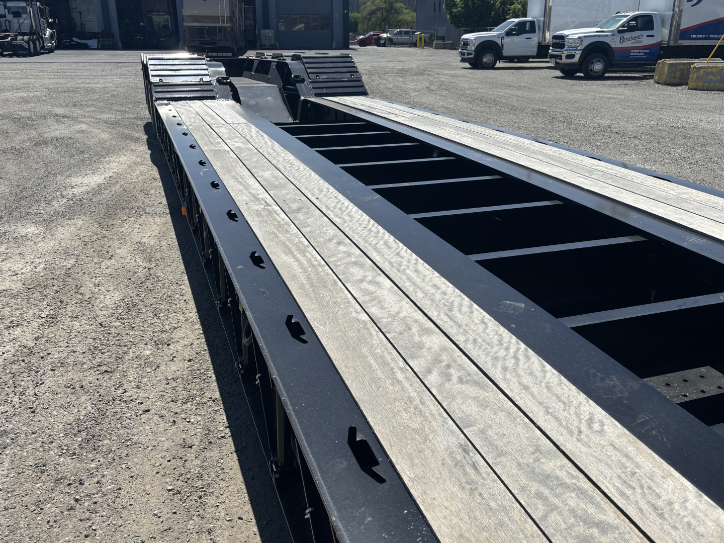 Load King trailer frame showing steel deck and support beams with mounting holes and rails.