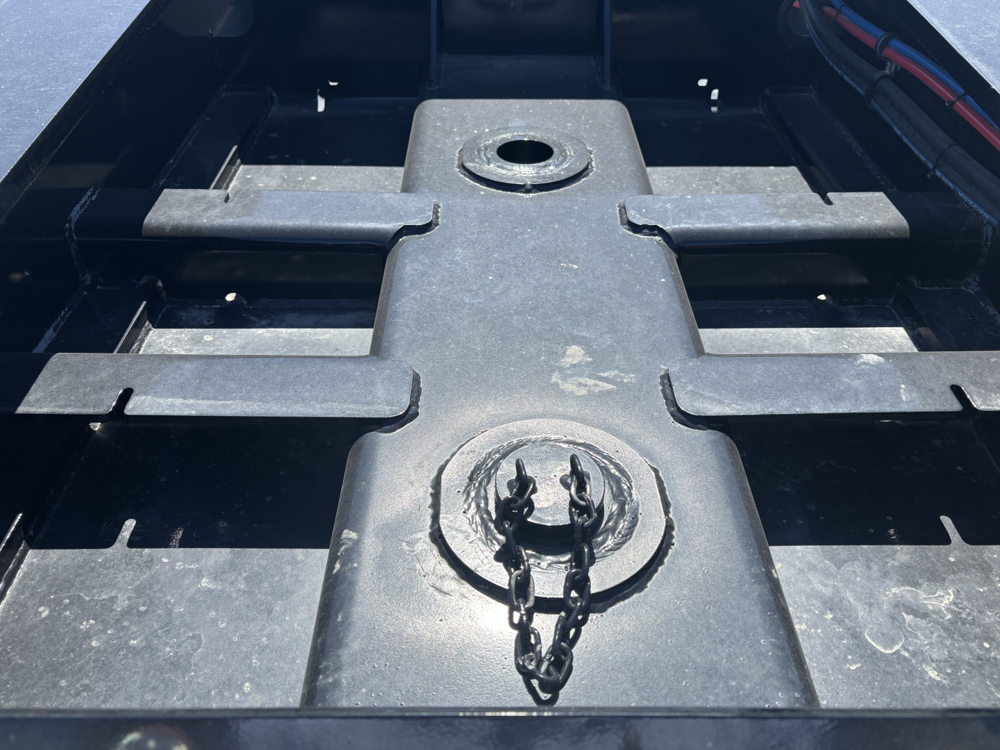 Trailer bed area showing feature plate with circular cap and chain, cross members and surface details