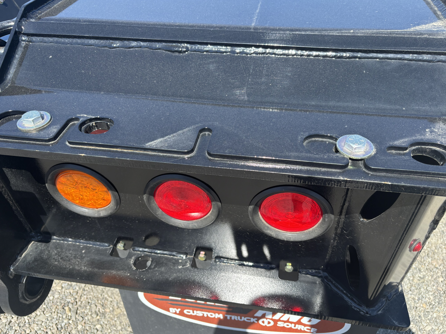 Trailer rear showing three circular taillights and hitch area on a Load King trailer.