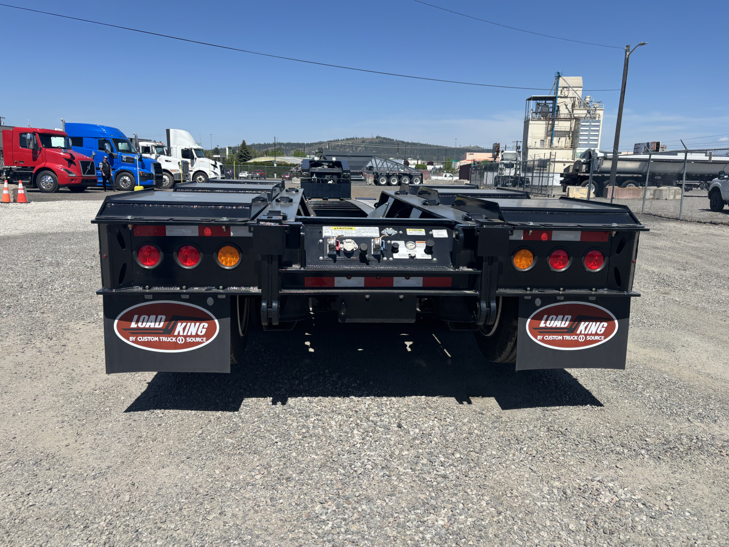 Trailer rear view showing Load King mud flaps and taillight assemblies on a lowboy trailer.