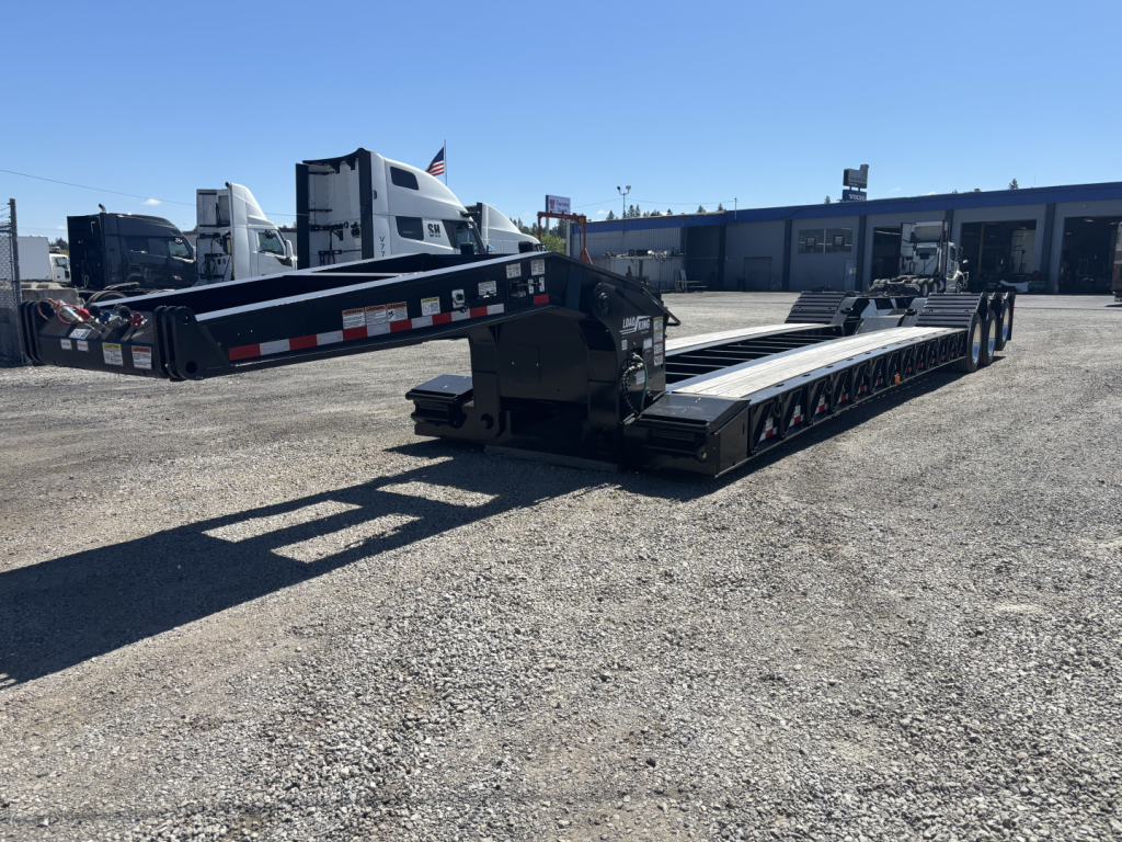 Load King lowboy trailer showing long flatbed and gooseneck area with black painted steel frame and multiple axles.