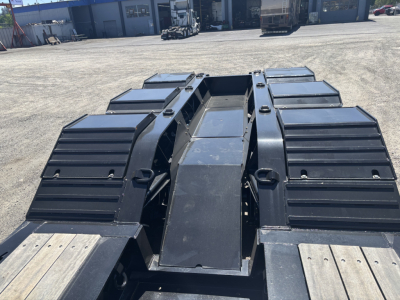 Trailer chassis showing heavy-duty Load King 9' 24" lowboy with side ramps and central I-beam frame.