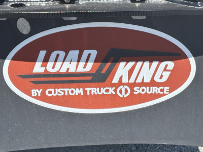 Trailer rear showing Load King logo sticker with red oval and white text on black surface.