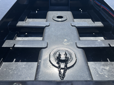Trailer bed area showing feature plate with circular cap and chain, cross members and surface details