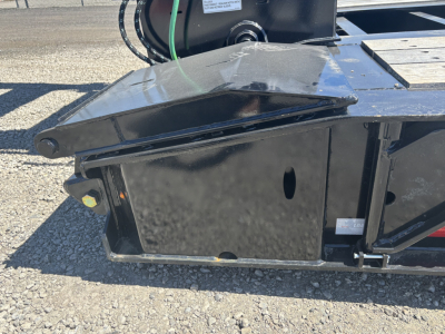 Load King trailer component view showing steel frame and hitch with black paint and a small label plate visible.