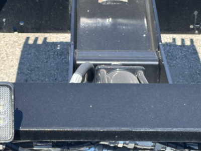 Trailer hitch area showing a black steel frame with a hydraulic winch/neck area and a hitch plate, no visible labels in frame.