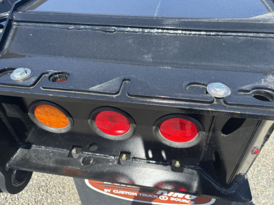 Trailer rear showing three circular taillights and hitch area on a Load King trailer.