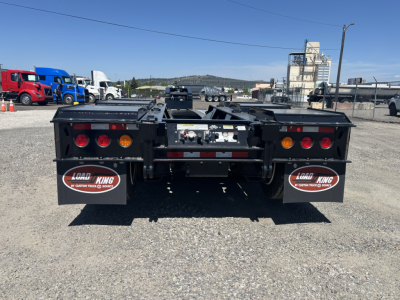 Trailer rear view showing Load King mud flaps and taillight assemblies on a lowboy trailer.