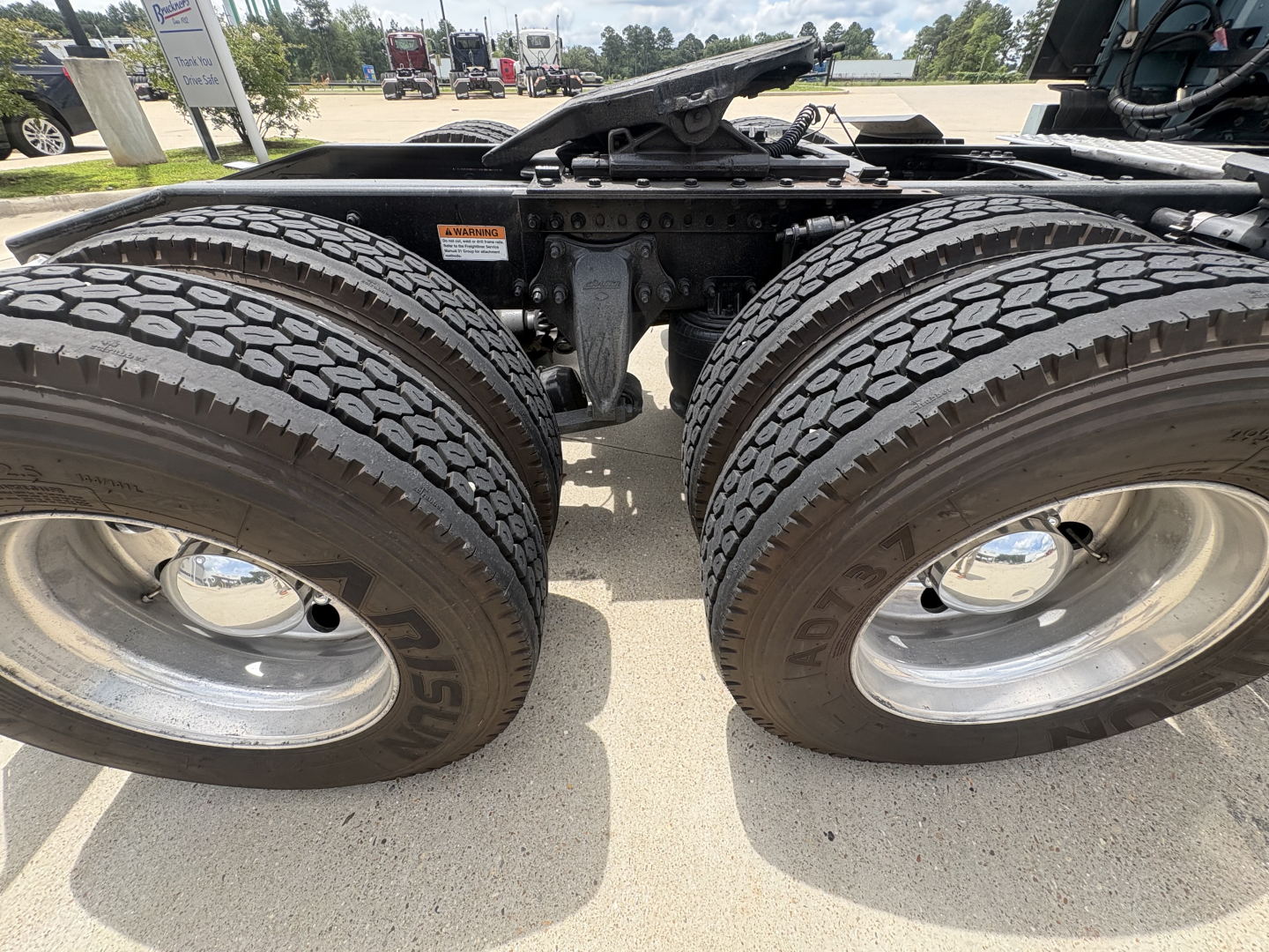 Freightliner Cascadia 126 chassis showing dual rear axles with large tires and suspension components.