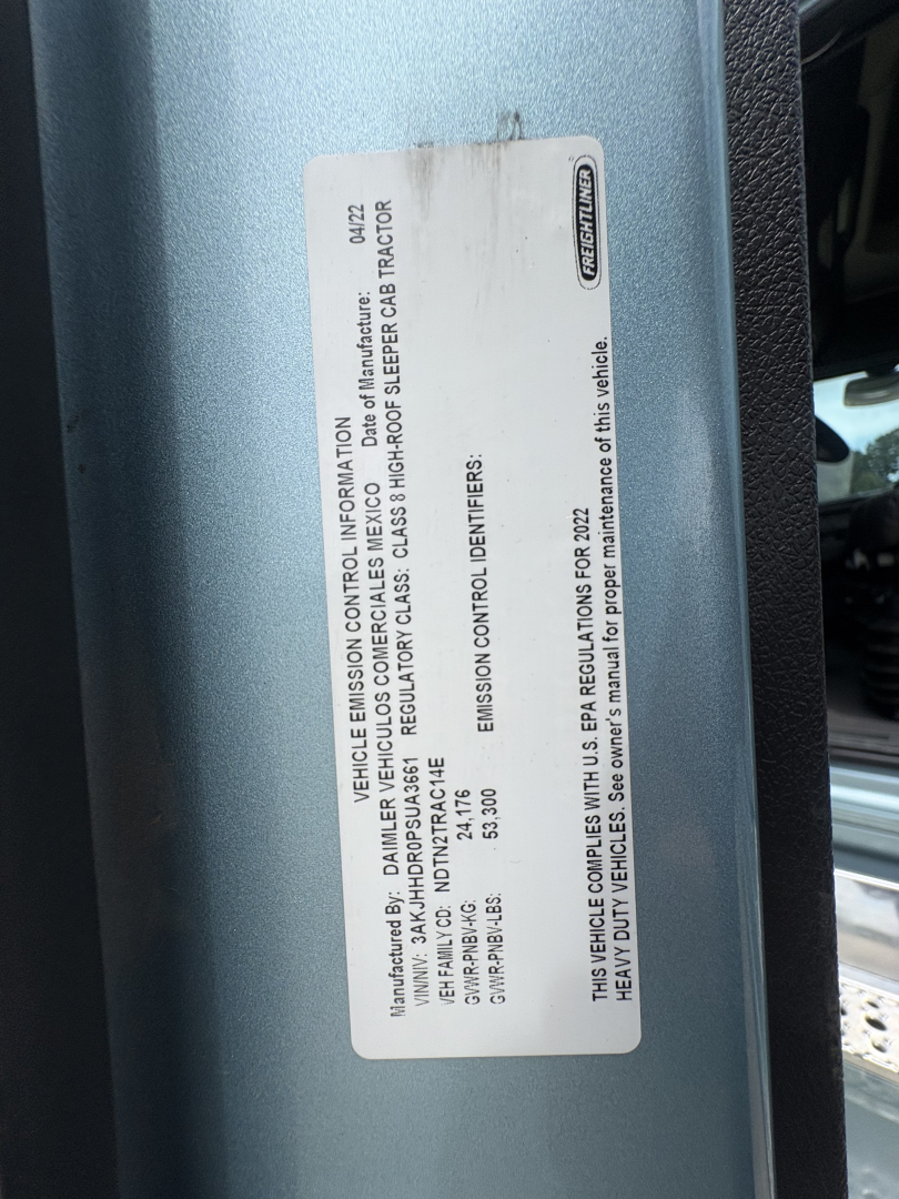 Label on Freightliner Cascadia showing vehicle emission information plate with VIN and chassis details