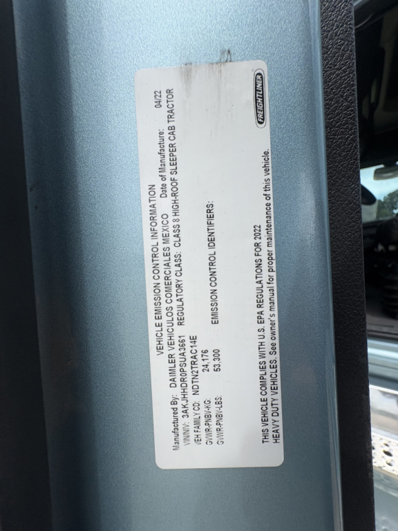 Label on Freightliner Cascadia showing vehicle emission information plate with VIN and chassis details