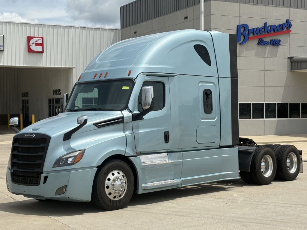 Freightliner Cascadia 126 tractor in light blue parked outside with sleeper cab and twin rear axles.