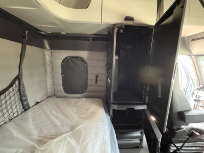Freightliner Cascadia 126 truck cabin interior with sleeper berth and cab area, side storage and doorway into sleeper