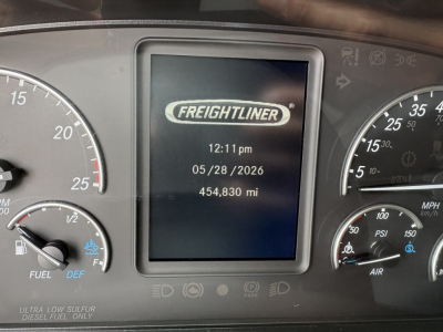 Dashboard display showing Freightliner logo with time 12:11 pm, date 05/28/2026, and 454,830 miles. Surrounding gauges include speedometer, fuel, DEF indicators.