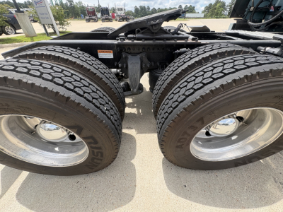 Freightliner Cascadia 126 chassis showing dual rear axles with large tires and suspension components.