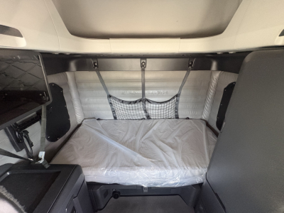Freightliner Cascadia 126 sleeper cab interior with bed and storage nets visible.