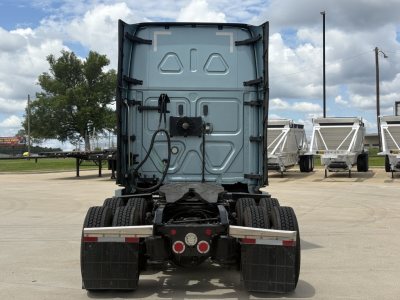 Truck cab rear view with Freightliner Cascadia sleeper chassis, dual rear axles, bumper lights, and wiring harness; no legible engine or model text visible.