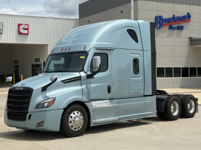 Freightliner Cascadia 126 tractor in light blue parked outside with sleeper cab and twin rear axles.
