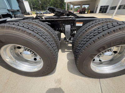 Dual rear axles of a Freightliner truck chassis with large tires and polished rims; visible are parts of the frame and air hoses; no legible serials or labels readable.