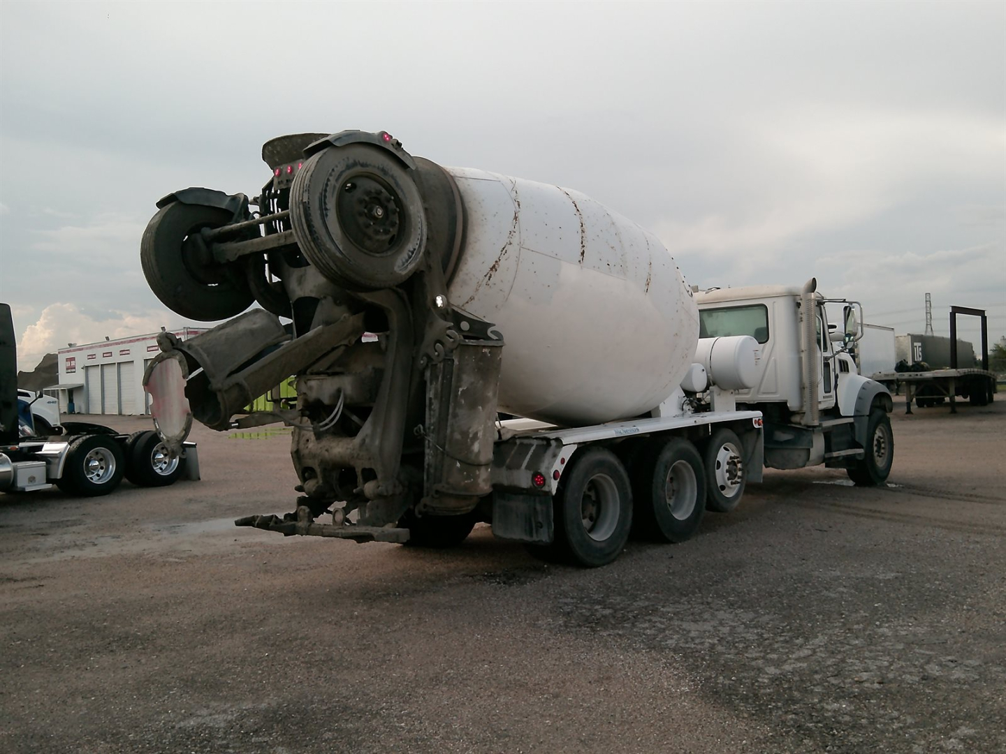 Mixer truck rear with cement mixer drum and attached power unit, side view.