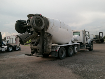 Mixer truck rear with cement mixer drum and attached power unit, side view.