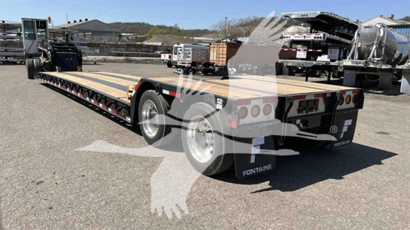 Fontaine Renegade lowboy trailer flatbed showing long deck, dual rear axles, and rear lights.