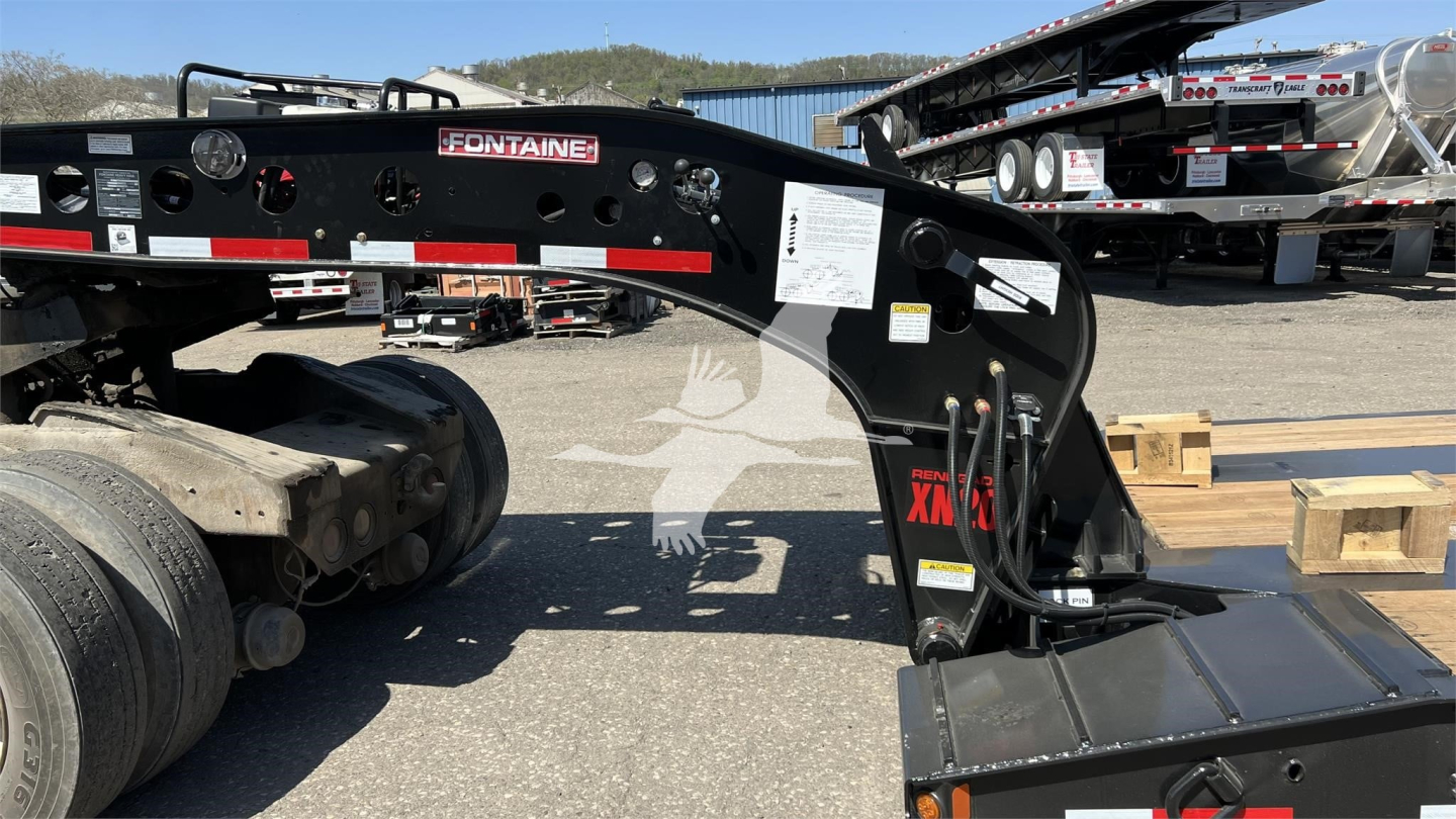 Fontaine XN20 lowboy trailer drawing visible with label 'Fontaine' on the frame, black paint, hydraulic components, and warning/caution stickers.