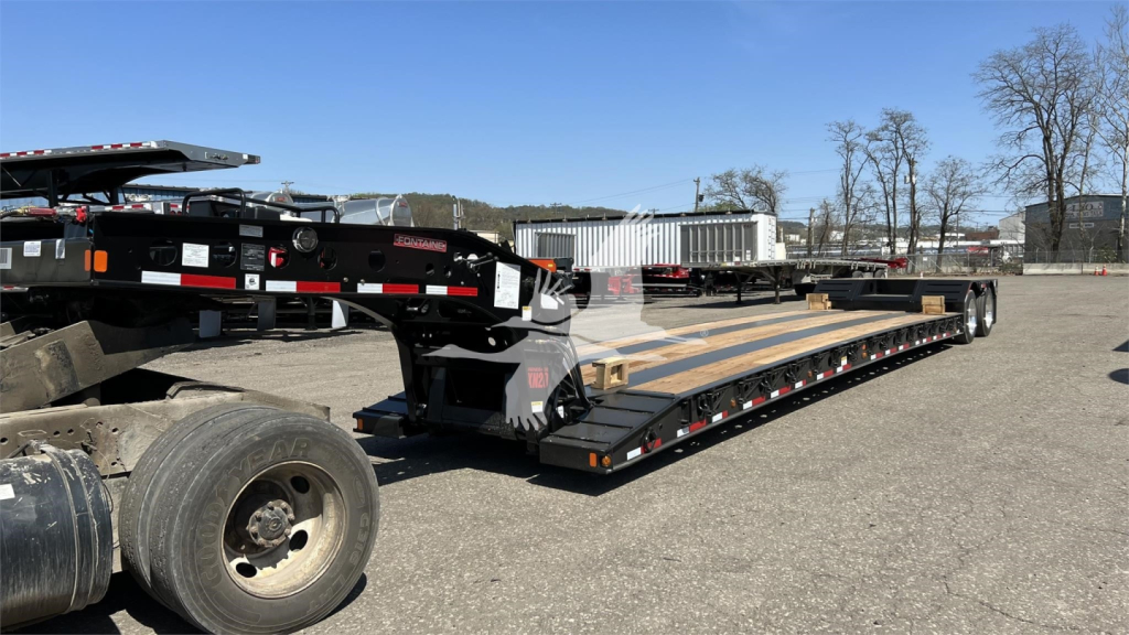 Fontaine XN20 lowboy trailer showing long flatbed with ramps and dual tires, label stickers visible on side.