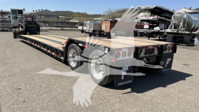 Fontaine Renegade lowboy trailer flatbed showing long deck, dual rear axles, and rear lights.