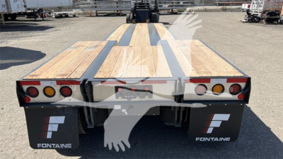 Fontaine Renegade Xn20 lowboy trailer rear view showing wooden deck and dual taillights with Fontaine mud flaps and stickers.