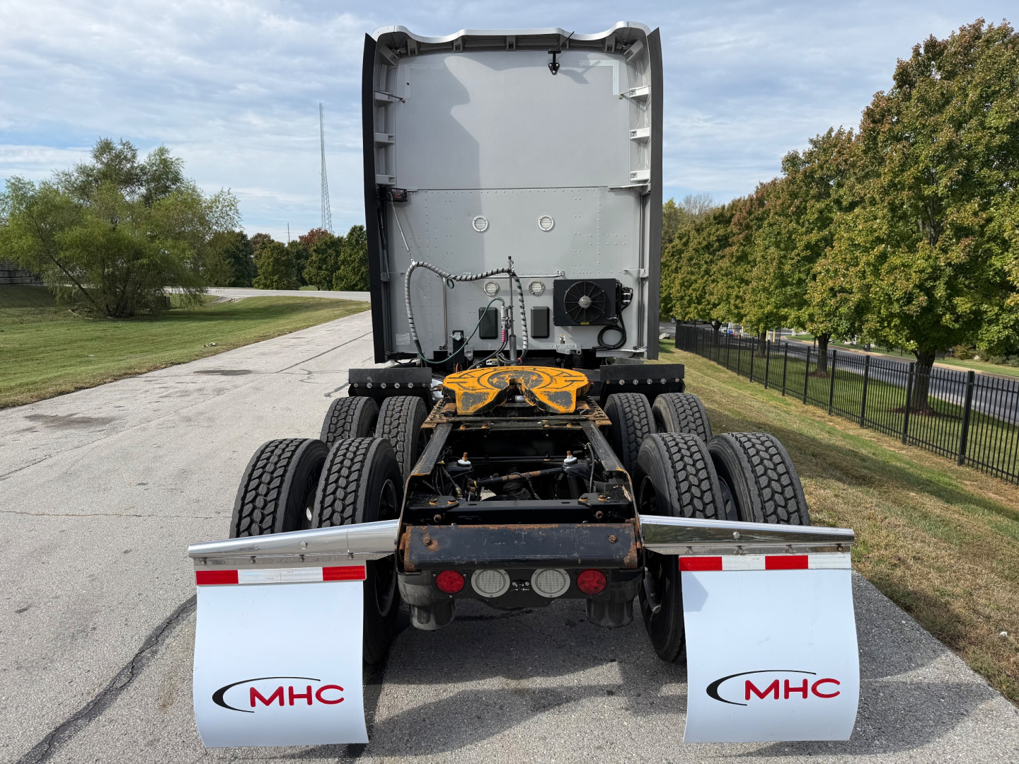 Kenworth T680 rear view showing chassis and fifth wheel with MHC branded mud flaps.