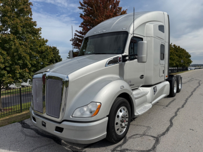 Kenworth T680 sleeper cab truck in silver, front-left view showing chrome grille, headlights, and side steps.
