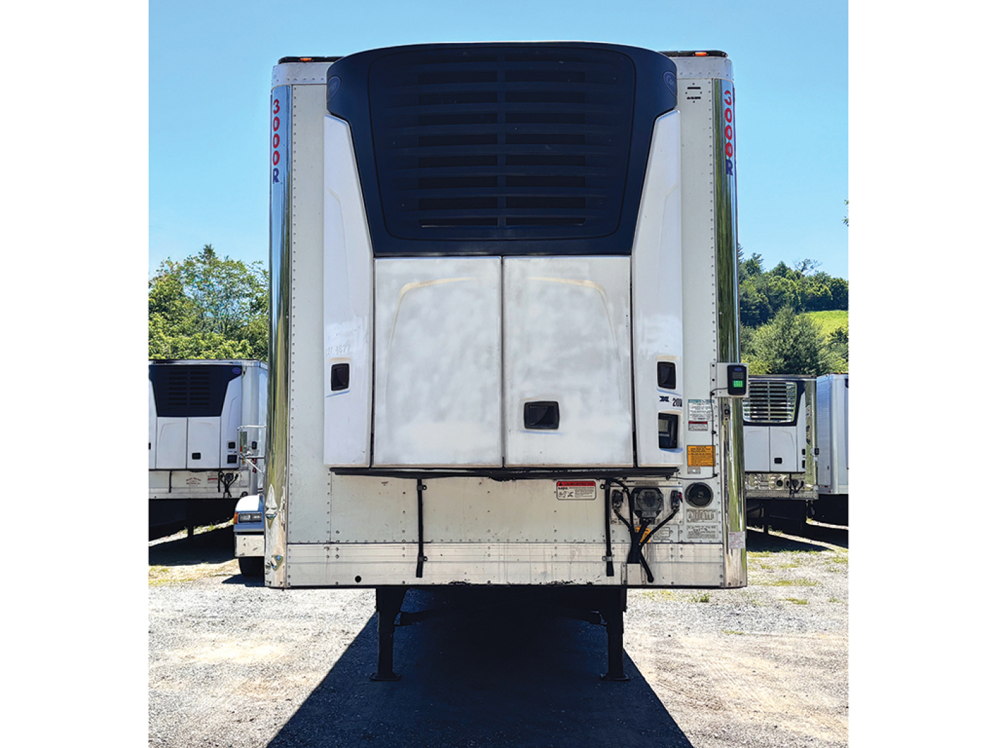 Trailer rear view showing reefer unit on a Utility 3000R, with lift gate, doors, and corner posts visible.