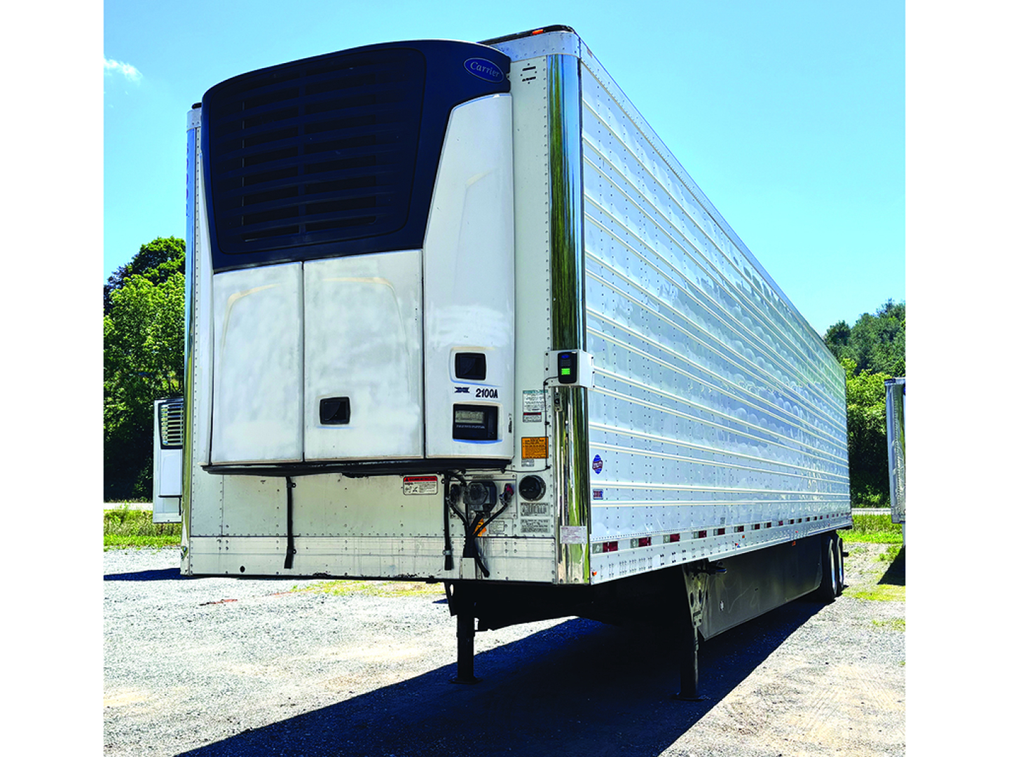 Utility 3000R trailer rear with reefer unit, white sides, blue refrigeration unit, side rails, and landing gear visible.