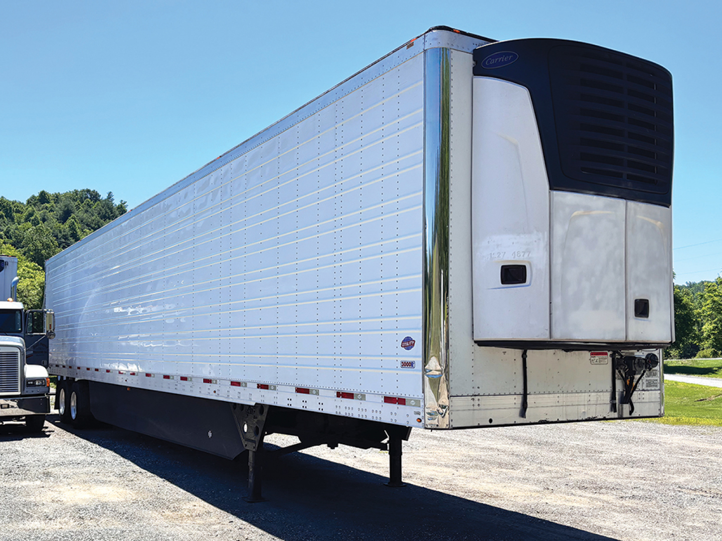 Trailer side of a 2020 Utility 3000R reefer trailer in service showing aluminum body and front refrigeration unit with black top; no visible text readable.