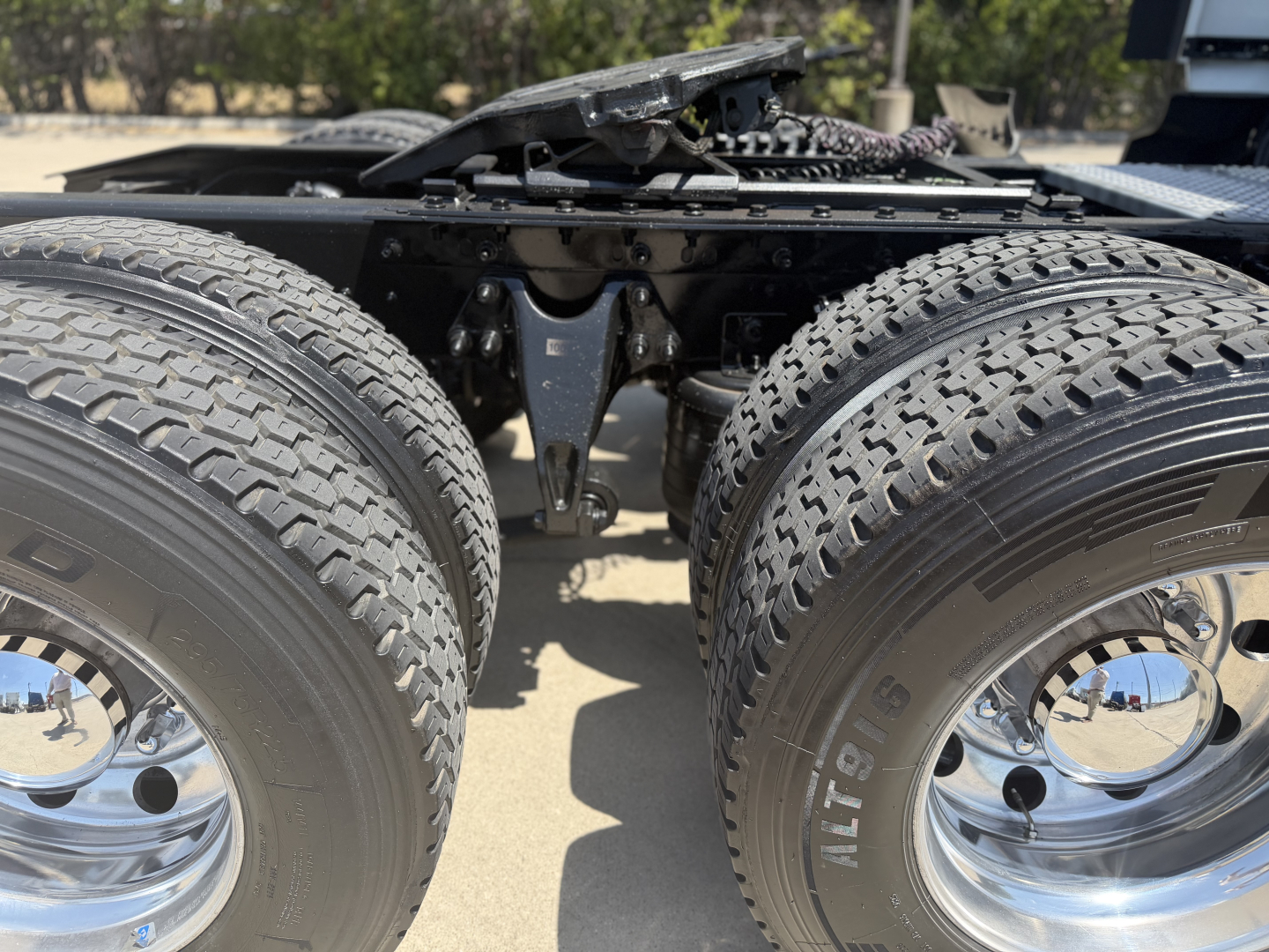 Truck chassis with dual rear axles and tires, undercarriage components visible