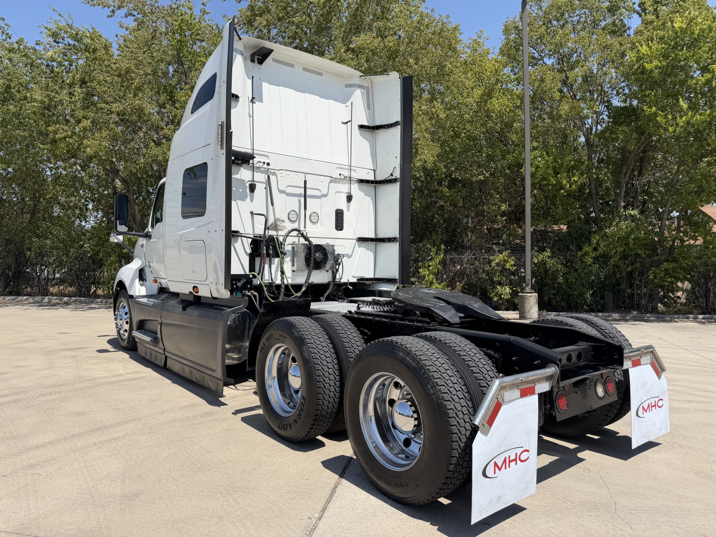 Truck: 2022 International LT625 sleeper tractor rear and side view with dual rear axles, white cab, chrome wheels, and mud flaps labeled MHC.