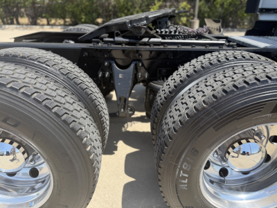 Truck chassis with dual rear axles and tires, undercarriage components visible