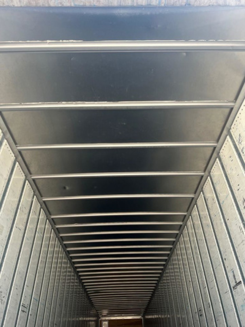 Trailer interior showing vertical walls and overhead ribbing of a utility van cargo space.