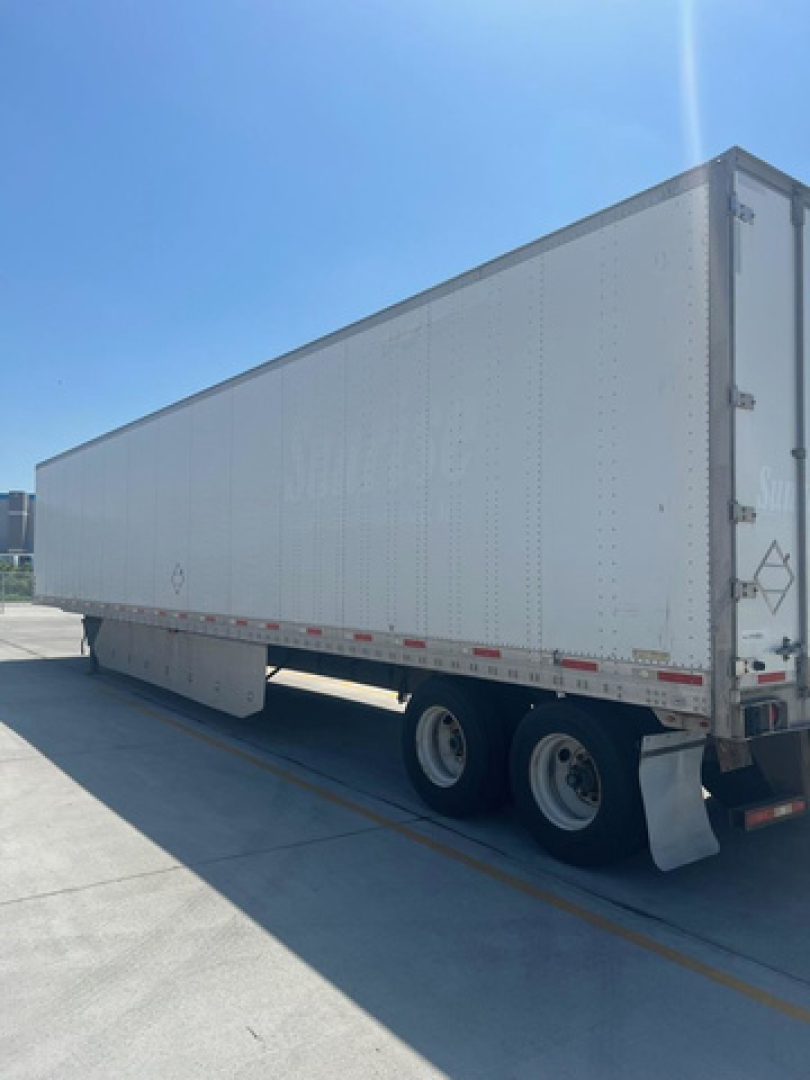 Utility van trailer showing side view with white exterior and dual rear axles.