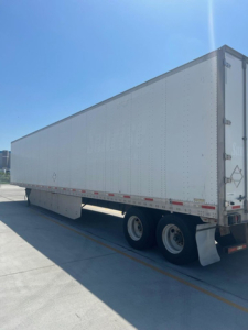 Utility van trailer showing side view with white exterior and dual rear axles.