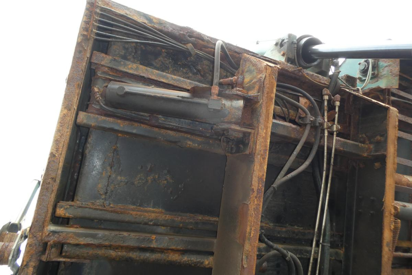 Mack GU Granite GU712 dump truck components visible with hydraulic cylinders and rusted frame.