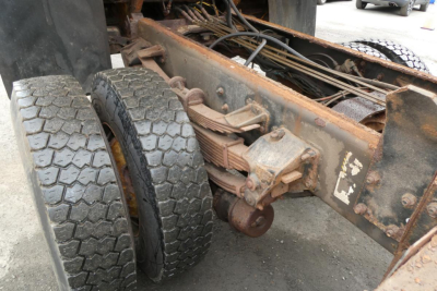 Rear suspension and dual rear tires of a 2010 Mack GU dump truck chassis showing leaf springs and axle components.