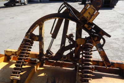 Mack GU Granite dump truck component with yellow framework and heavy springs showing a portion of the bed and hitch.
