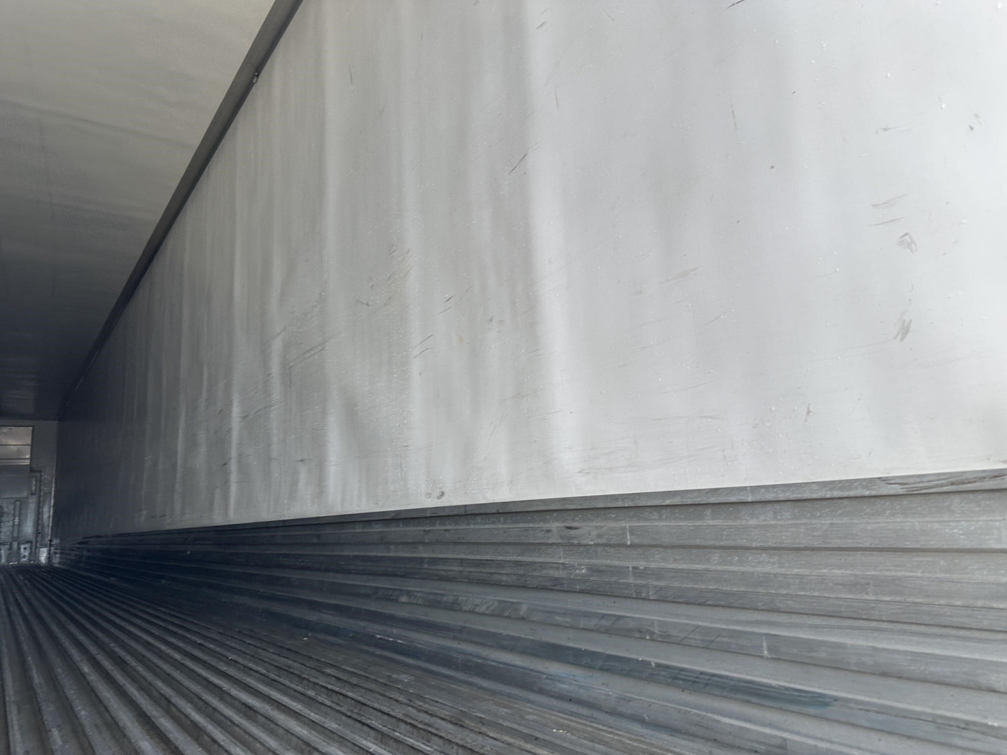 Trailer side interior showing aluminum walls and ribbed floor of a reefer trailer, Utility 3000R branding not visible.