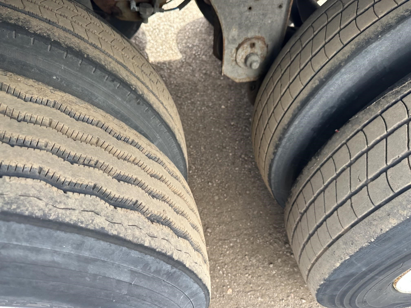 Trailer wheel ends with dual tires in view on a Utility 3000R reefer trailer, showing tread patterns and tire sidewalls.